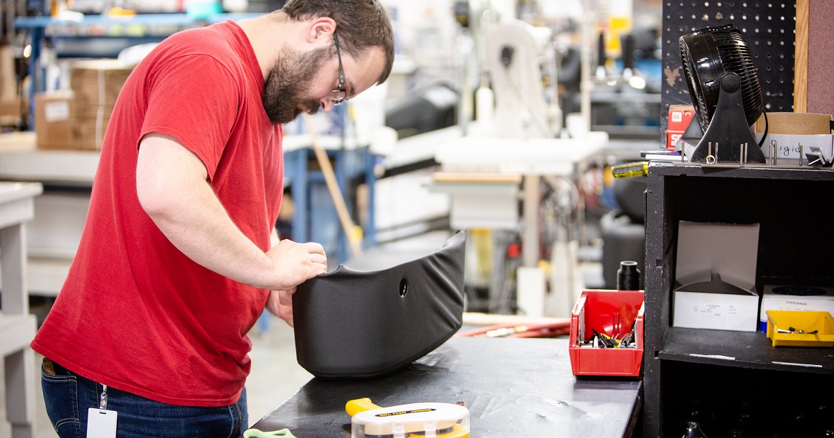 Employee assembles leather part