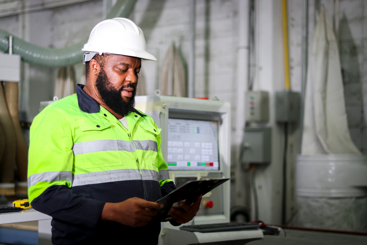Industrial worker man with whiskers wearing helmet and safety vest