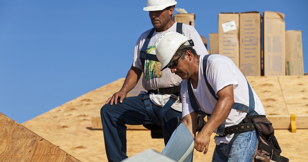 Roofers work on a roof in the sun and heat