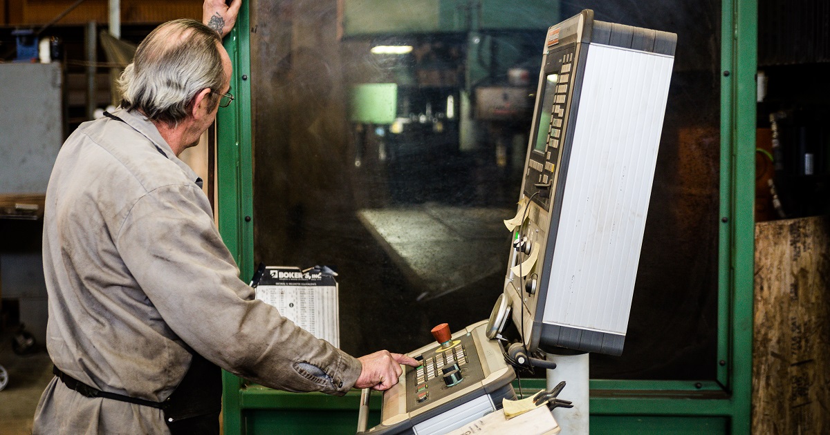 Worker stands at control panel